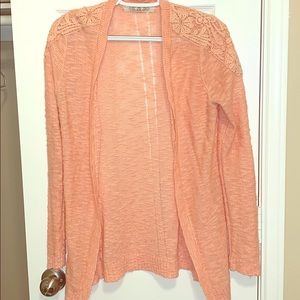 Orange cardigan with detail on front of shoulder